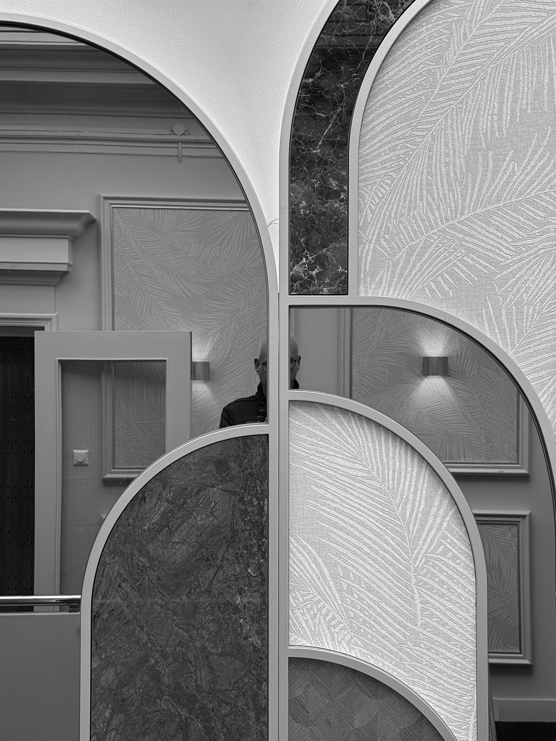 Man partly obscured by overlapping curved interior panels.