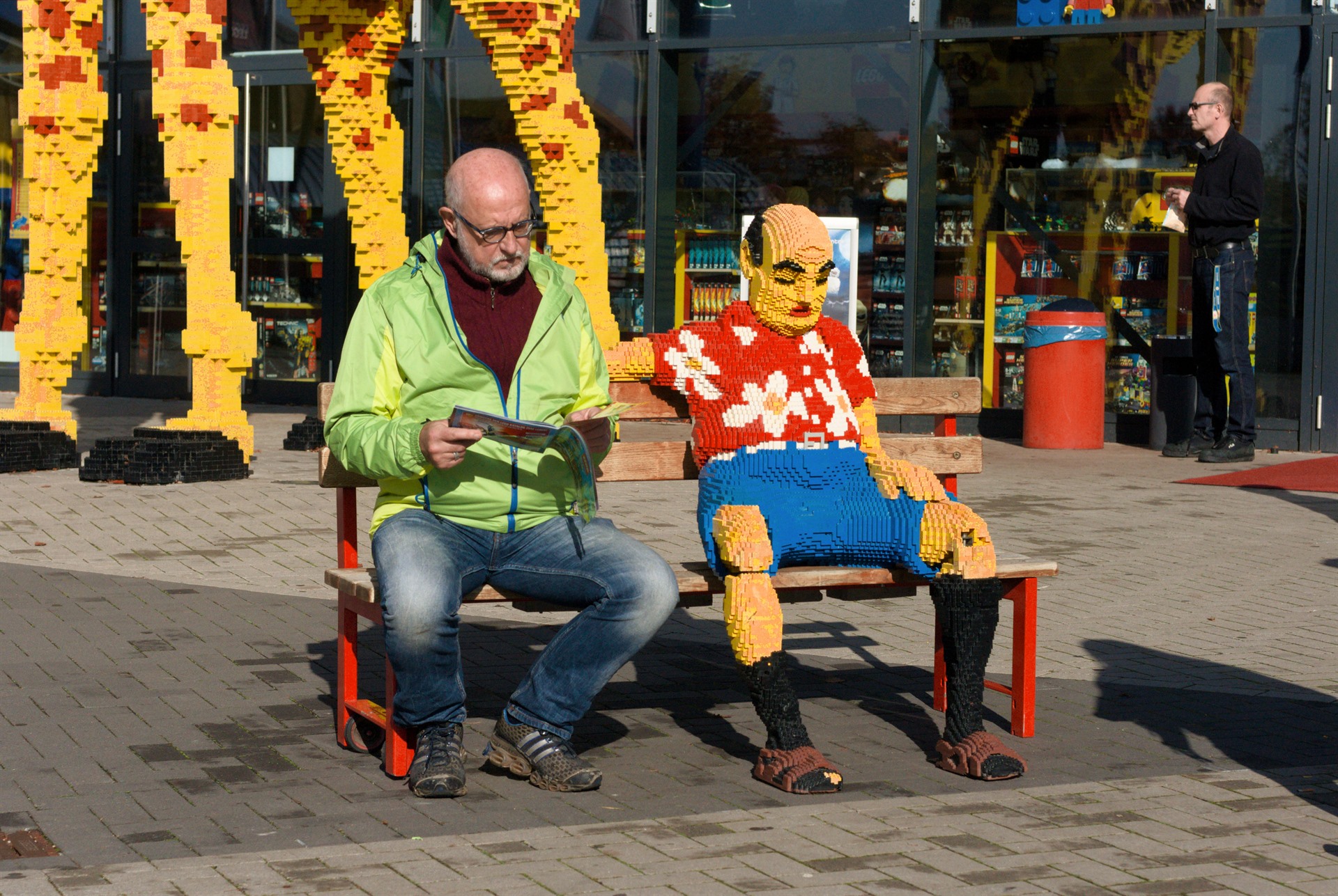 Man and child seated on brightly coloured chairs.
