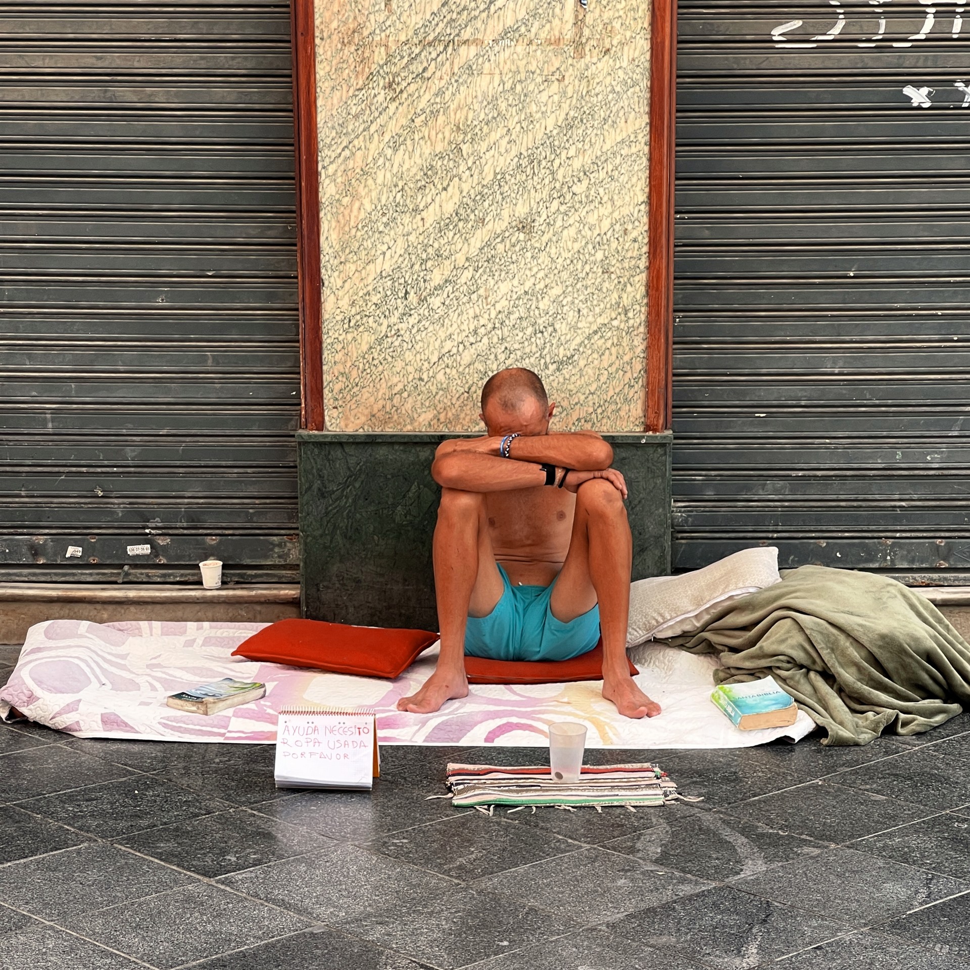 Seated man framed by turquoise and orange.